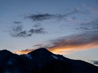 Dunkle Wolkenfetzen und rötliches Wolkenband über dem Aschauer Kopf